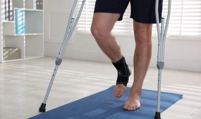 Man walking with an ankle brace and crutches
