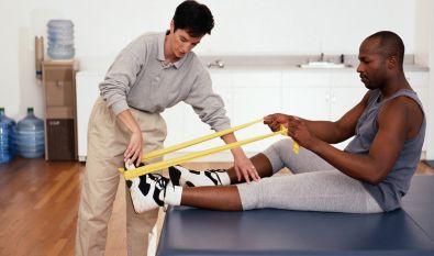 Physical therapist doing work conditioning physical therapy on an african american male