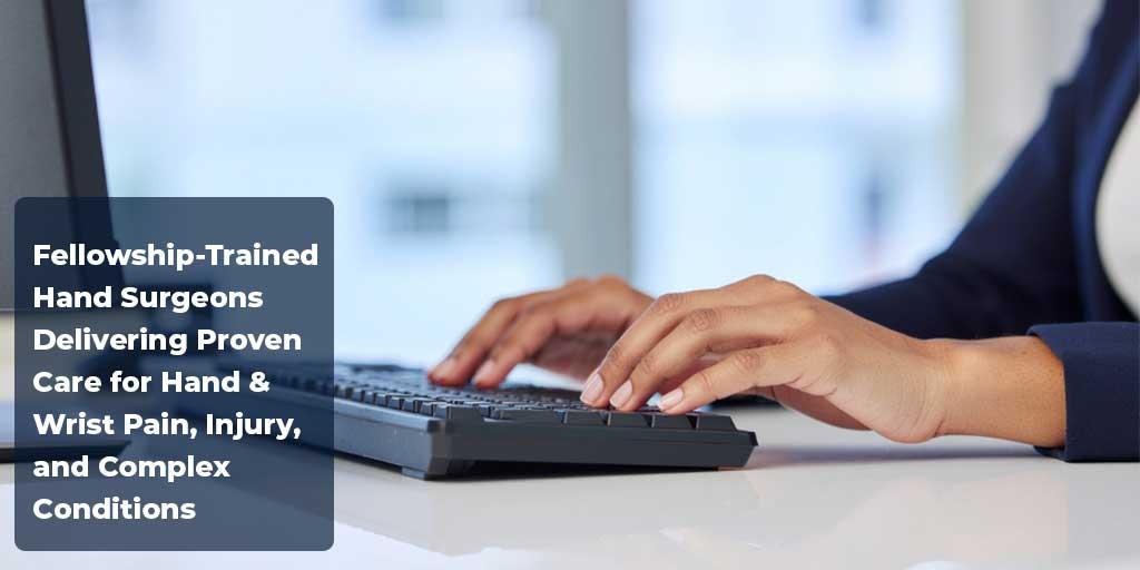 Close‑up of hands typing on a keyboard at a desk, with text promoting fellowship‑trained hand and wrist surgeons at Tidewater Orthopaedics.